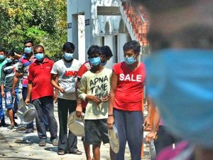The Migrant labours stand in queue to get their lunch at Gurunanak college in Velachery. (Photo | Ashwin Prasath, EPS)